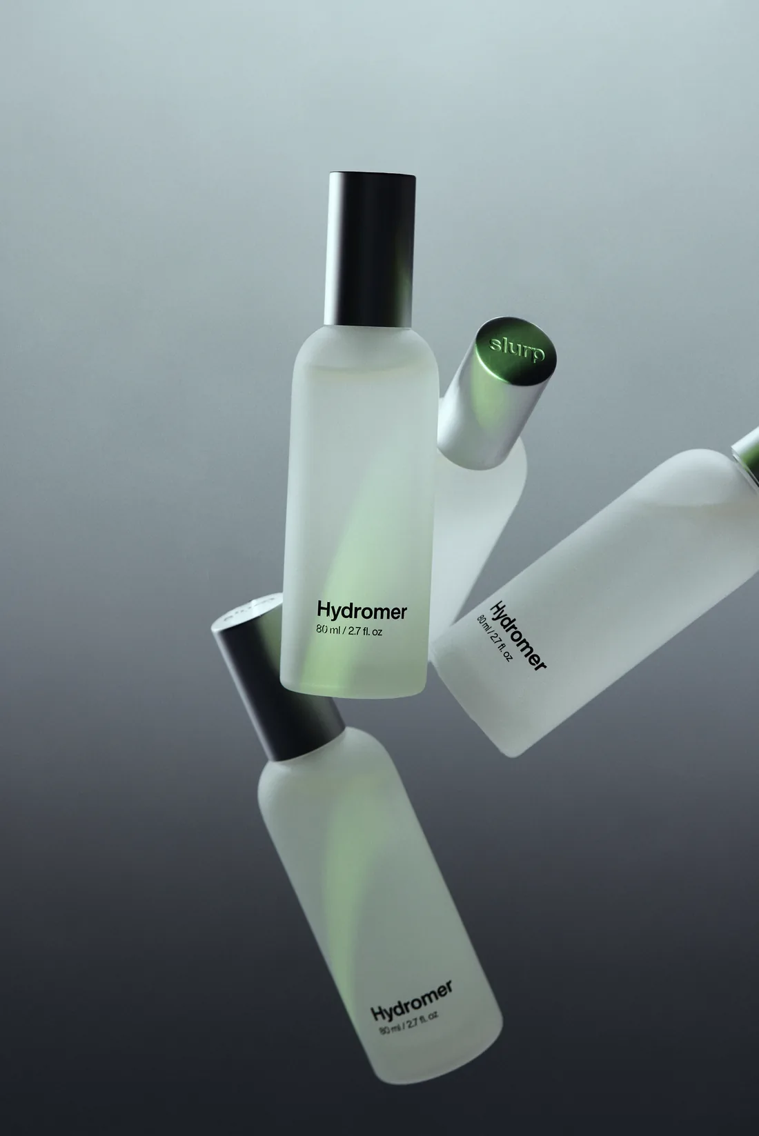 Frosted Hydromer bottles floating against a grey gradient