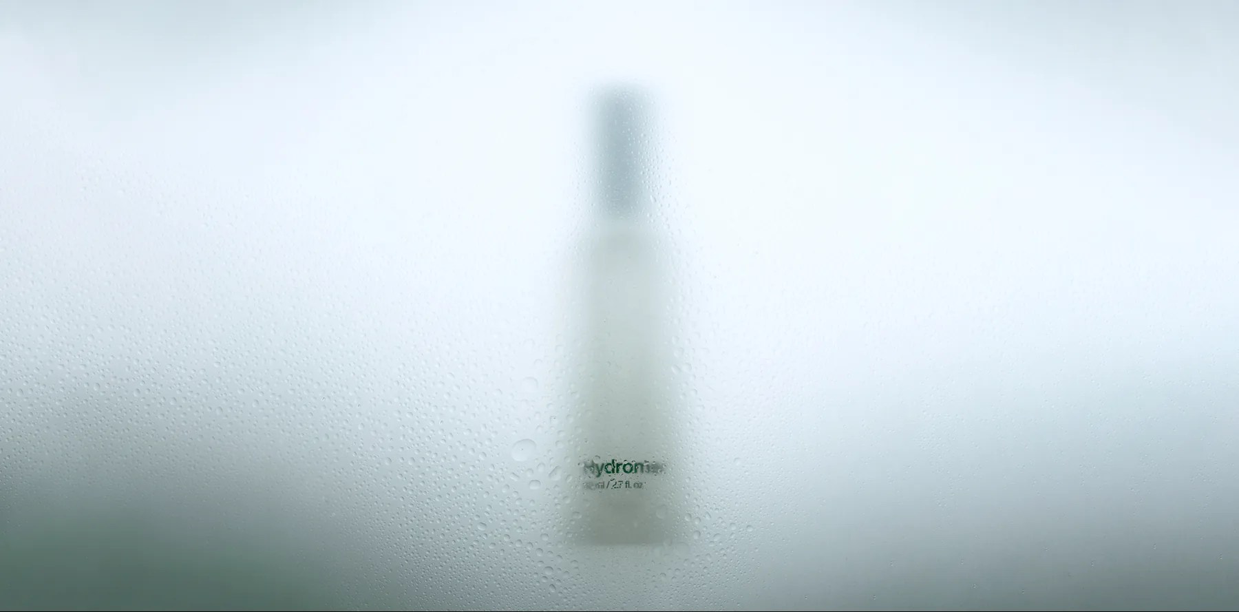 Hydromer bottle behind fogged, condensation-covered glass