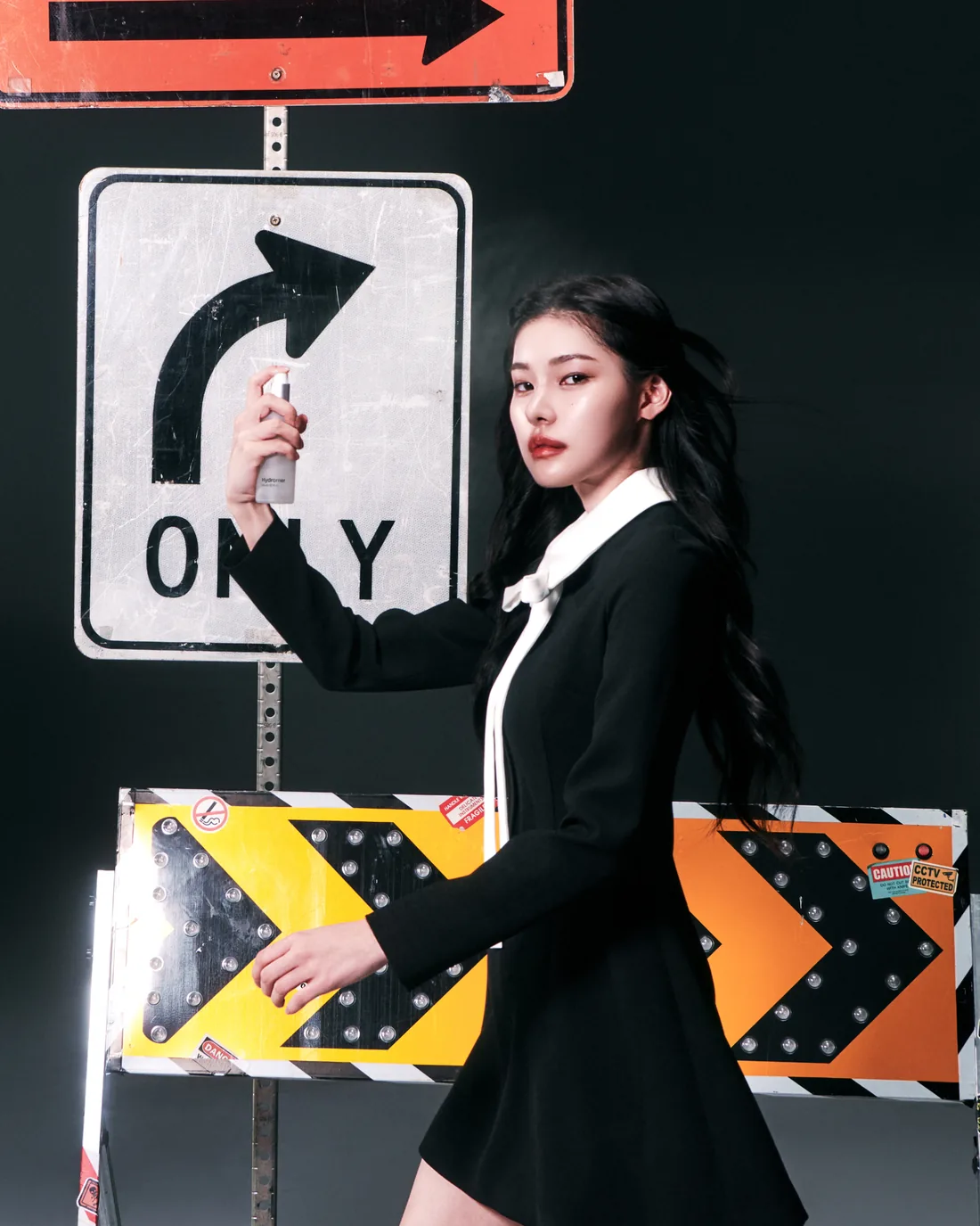 Model with Hydromer mist among road signs and traffic arrows