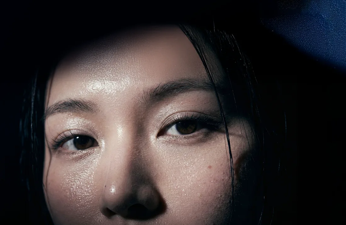 Beauty close-up: wet, luminous skin lit from the side