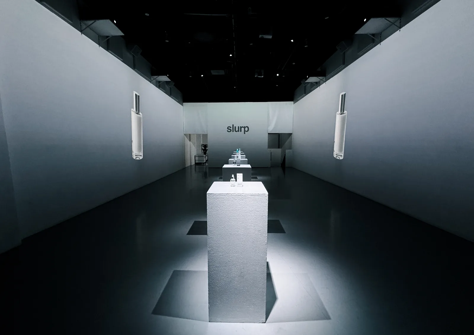 Lit plinths along the Slurp Laboratories event corridor
